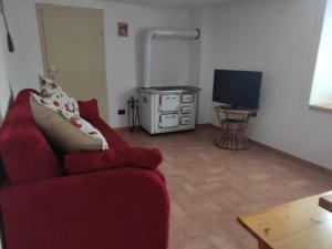 a living room with a red couch and a television at Casa Gemma in Vignola