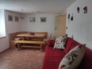 Casa Gemma في Vignola: غرفة معيشة مع أريكة حمراء وطاولة خشبية