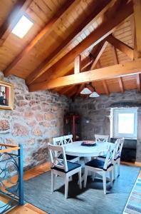 a dining room with a white table and chairs at Casa Rural d 'Avó - sossego do campo - 5 adultos in Alhais