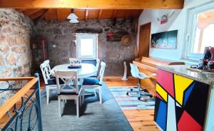 a dining room with a table and a piano at Casa Rural d 'Avó - sossego do campo - 5 adultos in Alhais