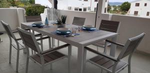 een eettafel met stoelen en een tafel met een stoel bij Piero's Apartment Calasetta in Calasetta