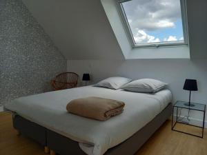 sypialnia z dużym łóżkiem i oknem w obiekcie Maison de vacances Lesconil à 500 m de la plage w mieście Plobannalec-Lesconil