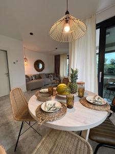 a living room with a table with chairs and a large chandelier at CUBE S in Medulin