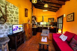 a living room with a red couch and a tv at Casa Clarita in Caño