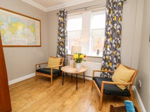 a living room with a table and chairs and a window at 8 Williamson Drive in Ripon