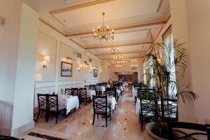 a dining room with tables and chairs and a chandelier at Steigenberger Cecil Hotel Alexandria in Alexandria