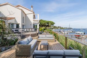 a deck with couches and a view of the water at Villa Front de Mer Accès Plage Presqu'île de Giens-Sea and Mountain Pleasure in Hyères