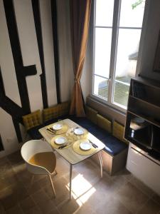 einen Tisch und Stühle in einem Zimmer mit Fenster in der Unterkunft A 2 Pas de Panthéon Quartiers Latins in Paris