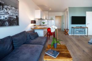 a living room with a blue couch and a kitchen at Weserloft 21 in Bremen