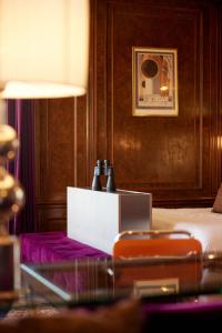 a room with a bed and a table with bottles on it at Hotel New York by WestCord in Rotterdam