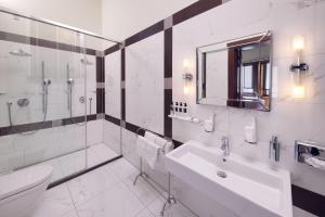 a white bathroom with a sink and a toilet at Hotel New York by WestCord in Rotterdam