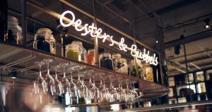 a bunch of wine glasses on a shelf in a bar at Hotel New York by WestCord in Rotterdam