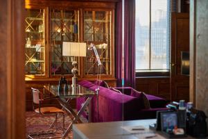 a room with a desk and a table with a lamp at Hotel New York by WestCord in Rotterdam