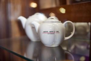 two white teapots are sitting on a glass table at Hotel New York by WestCord in Rotterdam
