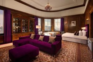 a living room with a purple couch and a bed at Hotel New York by WestCord in Rotterdam