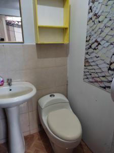 a bathroom with a white toilet and a sink at Coronado1936 in Cusco