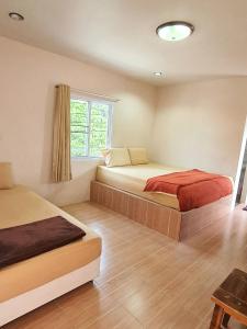 1 dormitorio con 2 camas y ventana en Sairee Center Guest House, en Ko Tao