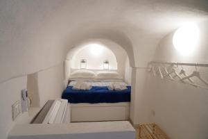 a small white room with a bed with blue sheets at CasaBella - con TERRAZZA PANORAMICA in Ostuni