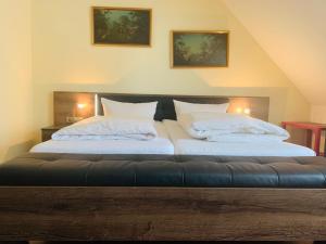 a white bed with a white comforter and pillows at Hotel-Restaurant Buger Hof in Bamberg