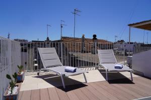 two white chairs sitting on a deck on a roof at CasaBella - con TERRAZZA PANORAMICA in Ostuni