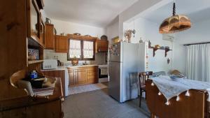 een keuken met een koelkast en een tafel. bij Sophia's cottage in Fourka