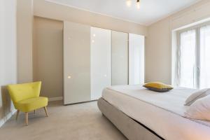 ein Schlafzimmer mit einem Bett und einem gelben Stuhl in der Unterkunft Mirror of the Sea Apartment 5 mt from the beach in Salerno