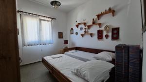 een slaapkamer met 2 bedden en planken aan de muur bij Sophia's cottage in Fourka