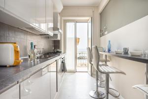 eine Küche mit einer Theke und Stühlen in der Unterkunft Mirror of the Sea Apartment 5 mt from the beach in Salerno