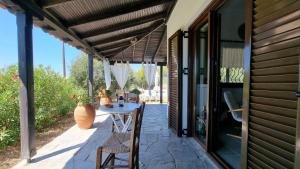 een patio met een tafel en stoelen onder een luifel bij Sophia's cottage in Fourka