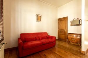ein rotes Sofa im Wohnzimmer in der Unterkunft Coeur Saint-Jacques in Brüssel
