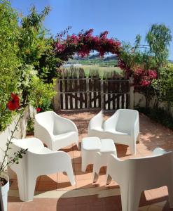 un gruppo di sedie bianche sedute su un patio di Le Torrette di Anna - Tropea a Briatico