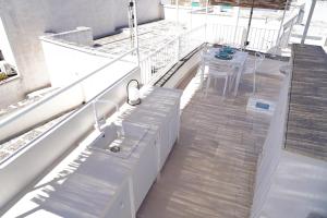a balcony with a white bench and a table at CasaBella - con TERRAZZA PANORAMICA in Ostuni