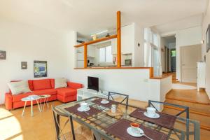 a living room with a table and a red couch at Apartamento Bellavista in Punta Grossa