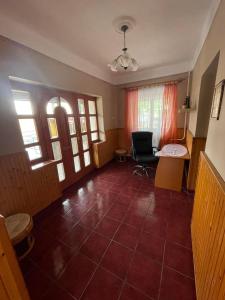 Jóbarát vendégház في Sáta: غرفة معيشة مع أرضية بلاط حمراء ونوافذ
