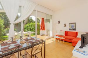 Apartamento Bellavista في بونتا غروسا: غرفة معيشة مع أريكة حمراء وطاولة
