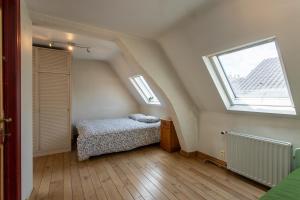 a attic bedroom with a bed and a window at Coeur Saint-Jacques in Brussels
