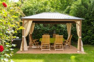 a wooden gazebo with chairs and a table at Schwalbenflug 1 Berlin in Berlin