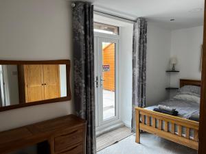 a bedroom with a bed and a mirror and a door at Castle House Holiday Home in Chapel en le Frith