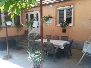 une table et des chaises assises à l'extérieur d'une maison dans l'établissement Evelin vendégház, à Bogács