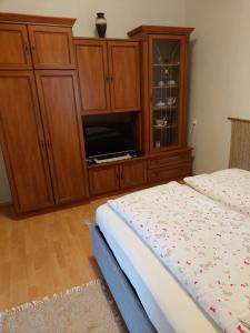 um quarto com uma cama e um armário de madeira em Evelin vendégház em Bogács