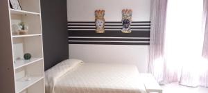 トラーパニにあるAppartamento Vittoriaの白と黒のストライプを用いたベッドルーム1室