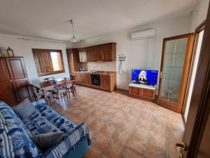 un soggiorno con divano e TV di Villino Figarolo a San Teodoro