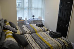 a bedroom with two beds with towels on them at Windmill Guest House in Bridlington