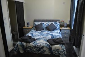 a bed with blue and white sheets and pillows at Windmill Guest House in Bridlington