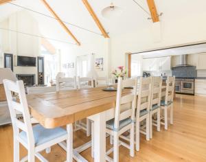 a kitchen and dining room with a wooden table and chairs at Ragleighs in Polzeath