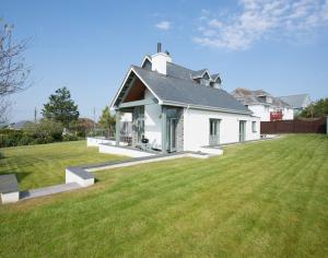 a large white house with a large grass yard at Ragleighs in Polzeath