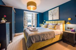 1 dormitorio con paredes azules y 1 cama grande en The Picture House, en Aldeburgh