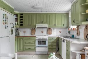 una cocina verde con electrodomésticos blancos y armarios verdes en Lovely house in Tranas with a wonderful location by the lake Loren en Tranås