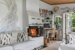 sala de estar con sofá y chimenea en Lovely house in Tranas with a wonderful location by the lake Loren en Tranås