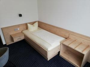 a small room with a wooden bed and a desk at Thüringer Hof in Richelsdorf